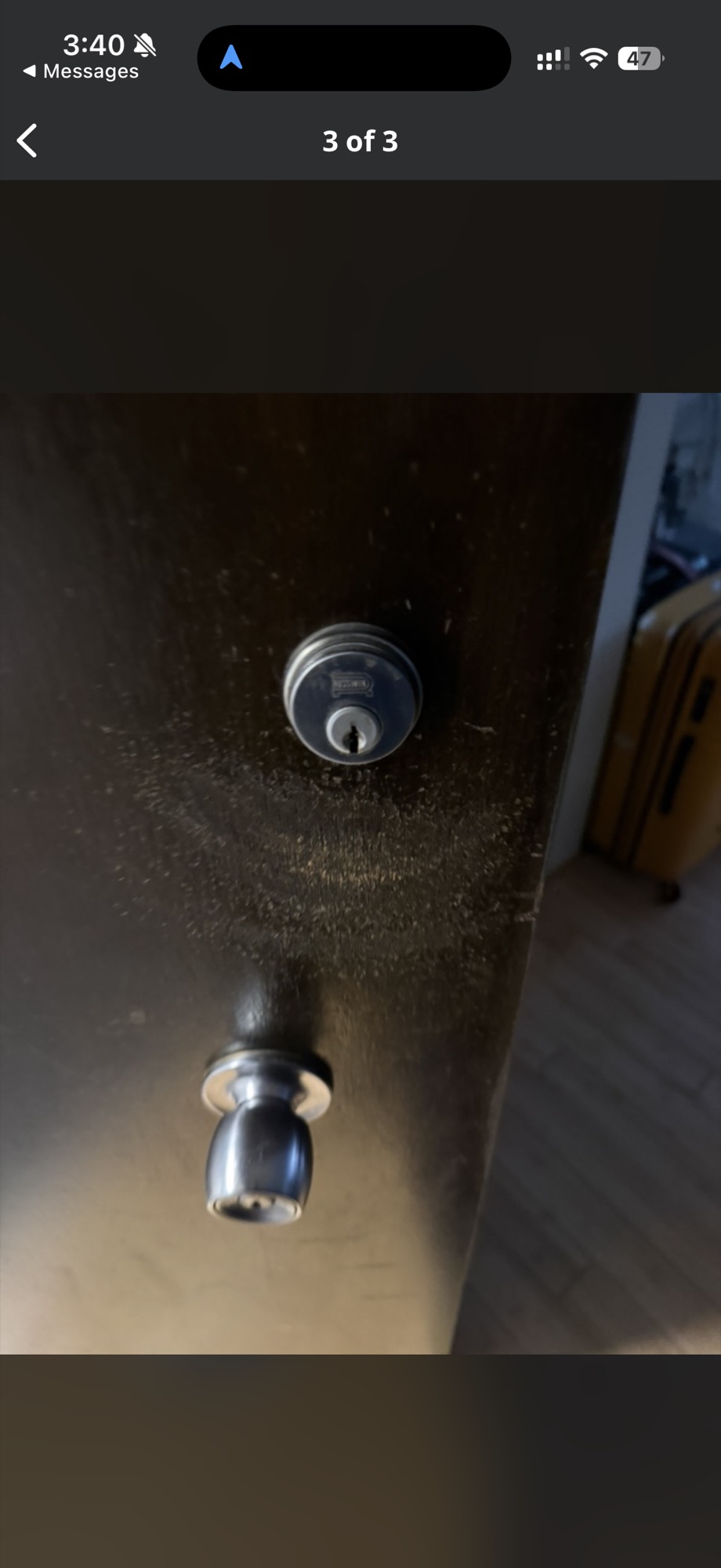 Deadbolt and knob lock cylinders on a dark door, viewed from inside
