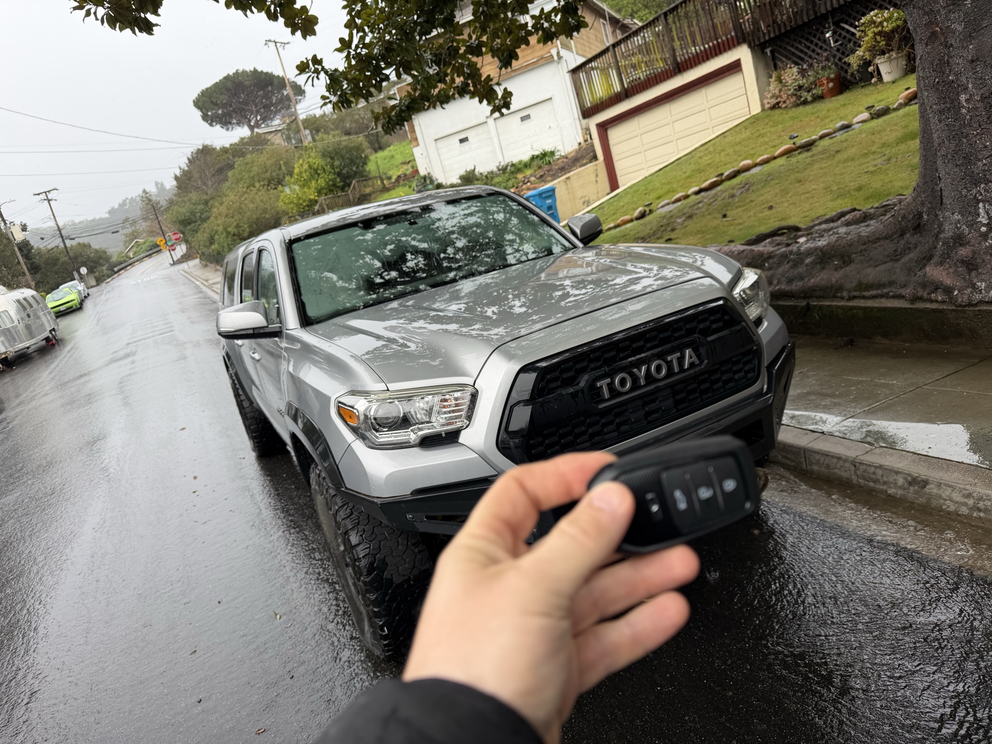 Replacement key fob for a silver Toyota Tacoma truck in the rain