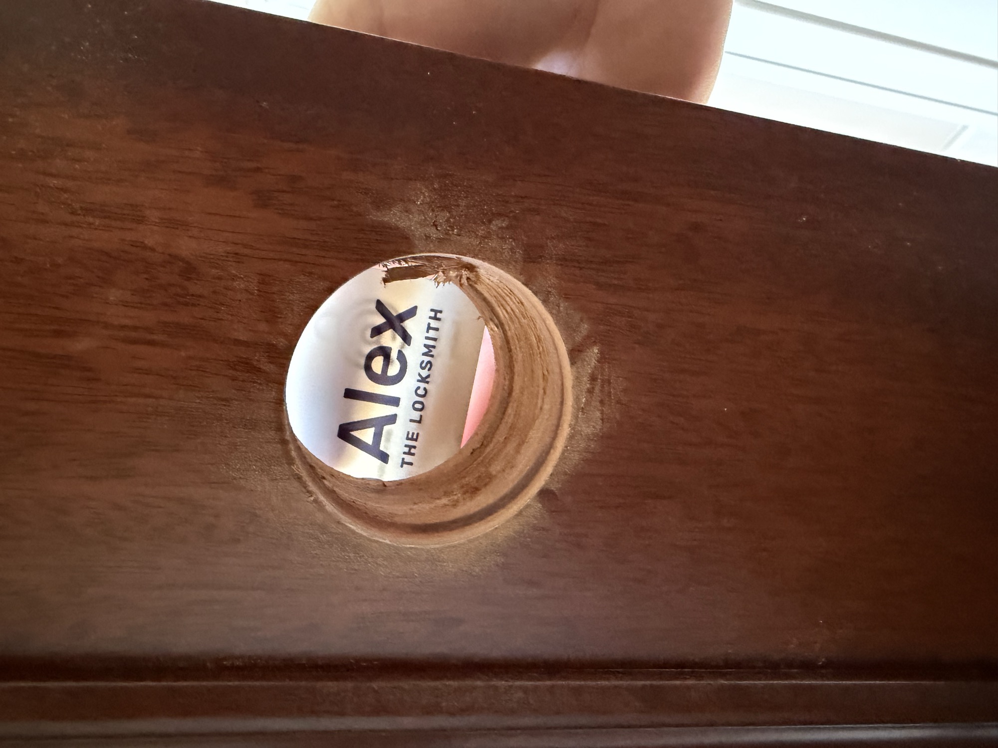 Business card viewed through a door peephole after cylinder replacement
