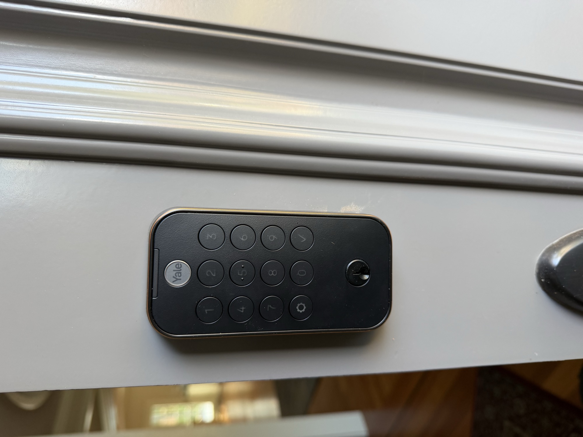 Yale electronic keypad deadbolt with keyed cylinder on a white door