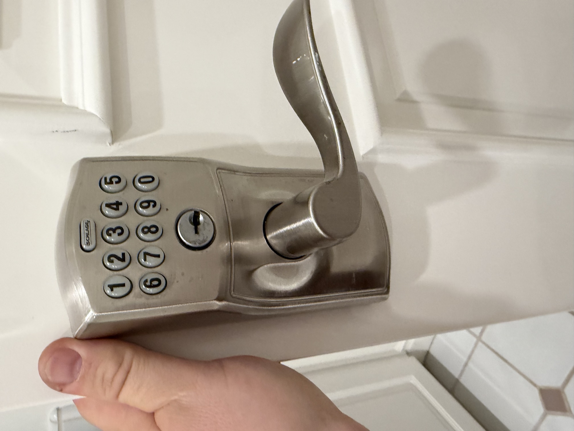 Schlage keypad lever lock with keyed cylinder on a white door