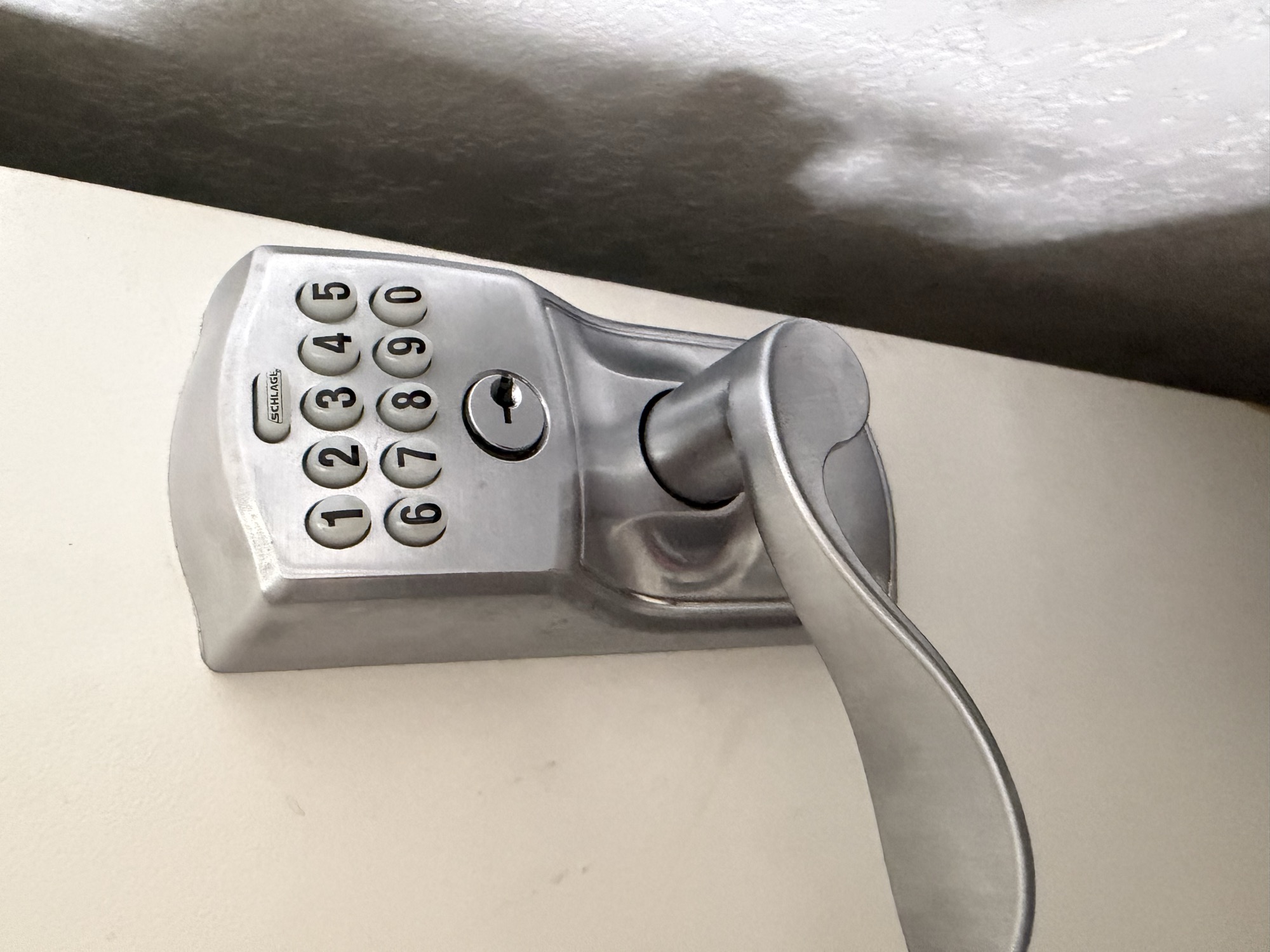 Schlage keyless entry lever lock installed on a light-colored door