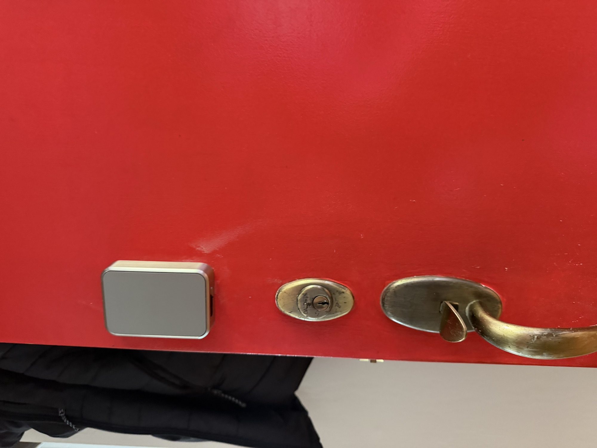 Baldwin deadbolt and lever handle with electronic access reader on a red door