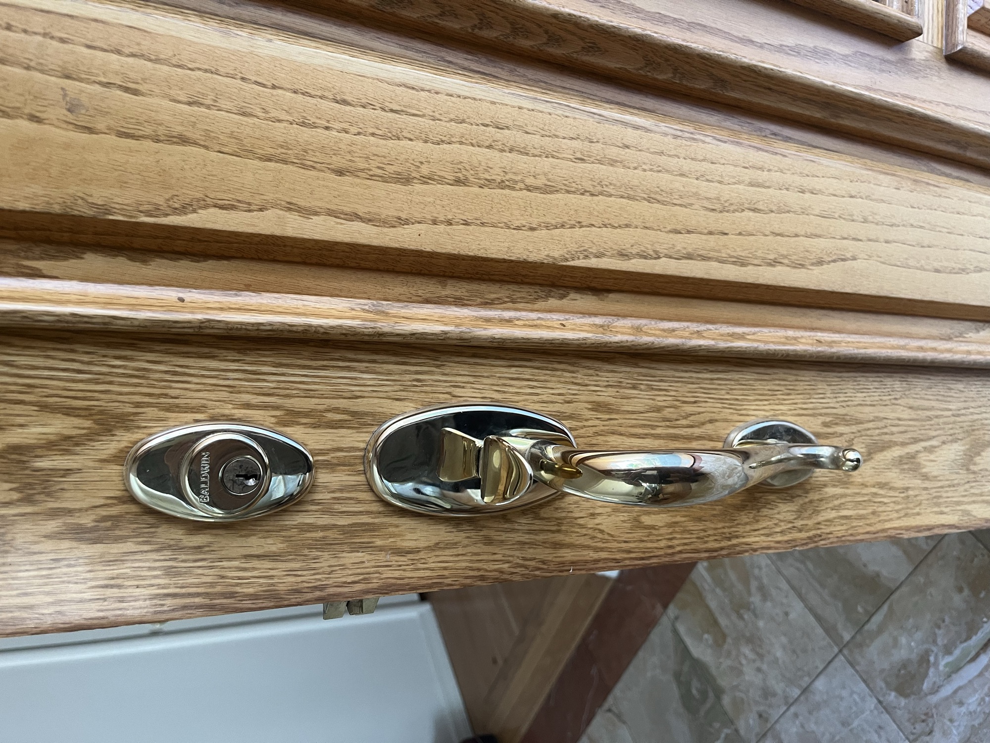 Baldwin deadbolt and brass entry handleset installed on a wood door